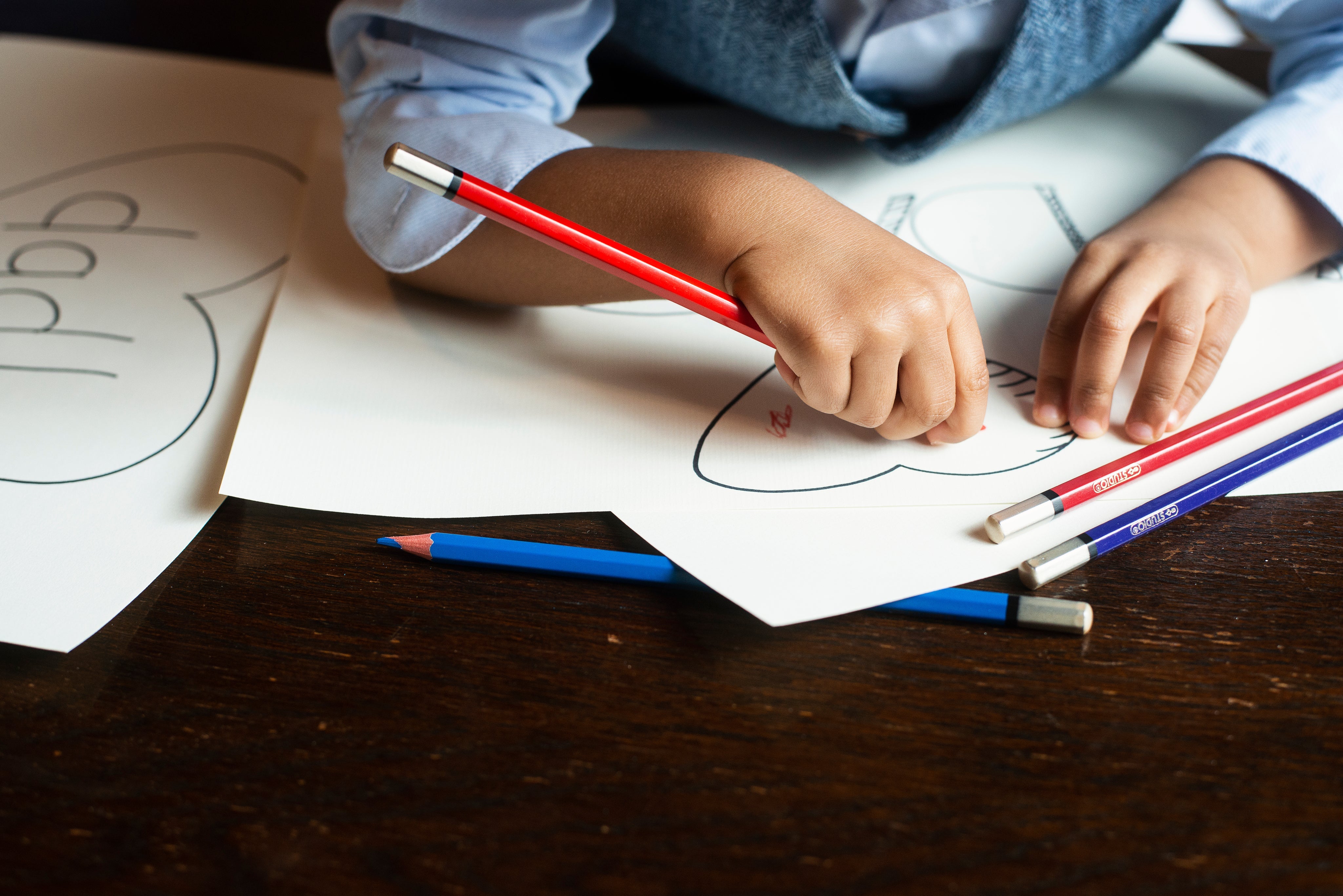 A toddler's hands coloring with a crayon