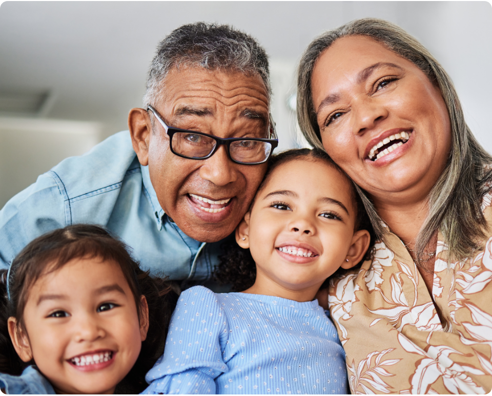 Grandparents smiling with their two young grandchildren