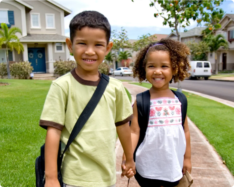 Two children with backpacks on the way to school