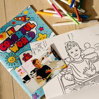 Coloring book titled 'My Colorful World' with markers and coloring pages on a wooden surface