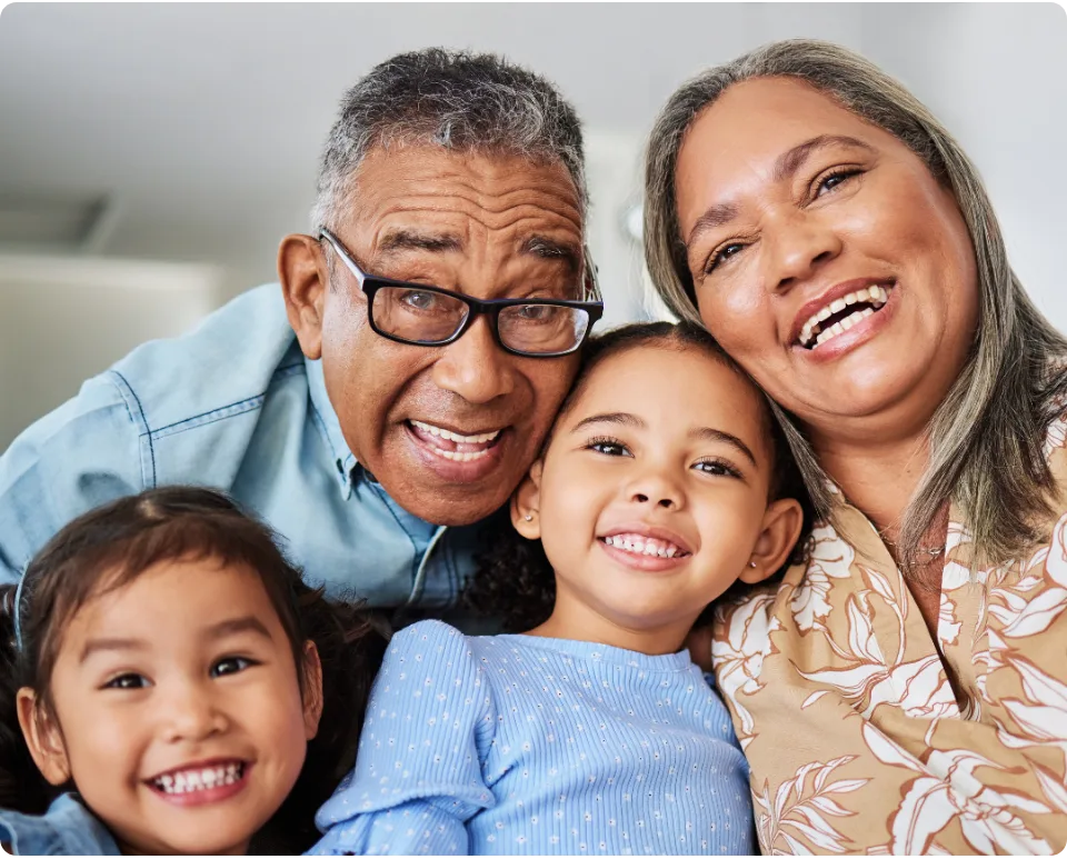 Grandparents smiling with their two young grandchildren